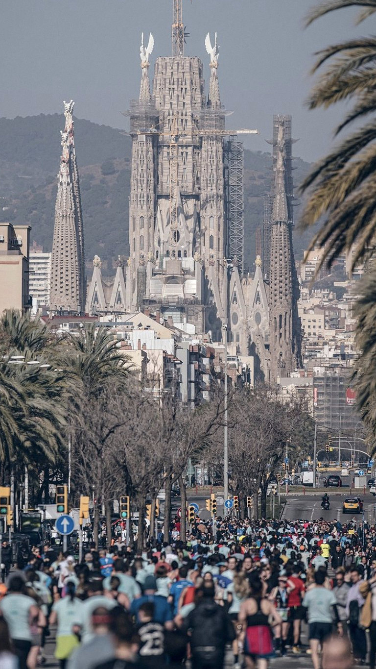 Avenida llena de corredores con la Sagrada Família al fondo